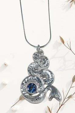 Silver pendant with blue gemstone on a white background